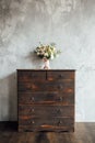 Wedding bouquet on dresser near gray wall with vintage texture Royalty Free Stock Photo