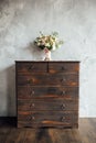 Wedding bouquet on dresser near gray wall with vintage texture Royalty Free Stock Photo