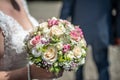 Wedding bouquet of flowers held by bride closeup. Pink and yellow roses flowers Royalty Free Stock Photo