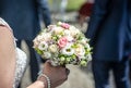 Wedding bouquet of flowers held by bride closeup. Pink and yellow roses flowers Royalty Free Stock Photo