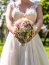 Wedding bouquet of flowers held by bride closeup. Pink and yellow roses flowers Royalty Free Stock Photo