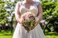 Wedding bouquet of flowers held by bride closeup. Pink and yellow roses flowers Royalty Free Stock Photo