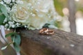 Wedding bouquet of fresh flowers, a pair of gold rings close-up. Wedding details