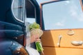 Wedding bouquet in hands of bride in black retro car with blue sky in background Royalty Free Stock Photo