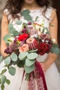 Wedding bouquet in the hands of the bride in boho style