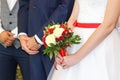 Wedding bouquet in hands of bride. The bride and groom in the registry office. Royalty Free Stock Photo