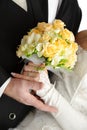 Wedding bouquet in hands of bride and groom, on wh