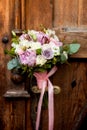 Wedding bouquet hanging on an old door handle on the background of ancient wooden doors. Royalty Free Stock Photo