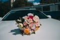 Wedding bouquet on the hood of a white car Royalty Free Stock Photo