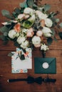 Wedding bouquet and invitation. stylish modern flowers and floral invitation boutonniere and bow tie on wooden background top view Royalty Free Stock Photo