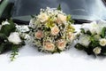 Wedding bouquet lies on the hood of white car Royalty Free Stock Photo