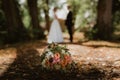 Wedding bouquet lying on path in park with wedding couple in background Royalty Free Stock Photo