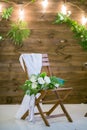 Wedding bouquet lying on wooden chair for wedding ceremony