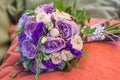 Wedding bouquet on an orange pillow, bouquet of bride from rose cream spray, rose bush, rose purple Memory Lane, violet eustoma, e Royalty Free Stock Photo