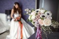 Wedding bouquet and out of focus bride in a wedding dress with a bouquet of flowers