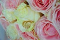 Wedding bouquet of pink and white roses and wedding rings lying on flower petals Royalty Free Stock Photo