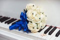 Wedding bouquet and ring lying on white piano. Royalty Free Stock Photo