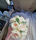 Wedding bouquet of roses of the bride in hand in the car. Royalty Free Stock Photo