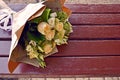 Bouquet of roses in pastel colors. Bridal bouquet on the wooden surface of the old bench. Empty space for text