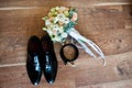 Wedding bouquet, shoes of groom and belt on wooden background.