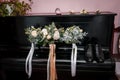 Wedding bouquet of white flowers, leather men's shoes, a pair of gold rings on a black piano Royalty Free Stock Photo