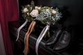 Wedding bouquet of white flowers, leather men's shoes, a pair of gold rings on a black piano Royalty Free Stock Photo