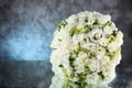 Wedding bouquet with white roses under the water drops on the mirror against grey and blue background. Royalty Free Stock Photo