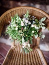 Wedding Bouquet On A Wicker Chair. Summer Bunch With Blue Thistle Flowers, Jana Roses, Eucalyptus And Olive Leaves, Black Berries,