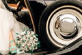 Wedding bridal bouquet with dried flowers cotton and largus near the car wheel, the bride`s leg and blue shoes Royalty Free Stock Photo