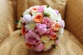 Wedding bridal bouquet with roses and other flowers on arm chair