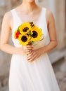 Wedding bridal bouquet of sunflowers in the hands of the bride.