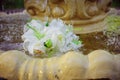 The Wedding Bridal Bouquet Of White Roses Lies In An Old Fountain Under Splashes And Drops Of Water. Royalty Free Stock Photo