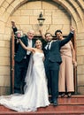 Wedding, bride and groom with parents on stairs, church and happiness at excited celebration. Marriage, couple and Royalty Free Stock Photo