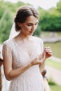Wedding. Bride. Preparations. Wedding Dress. Happy bride in white lace dress wears the earring on the balcony.earrings