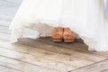 Wedding bride shoes and feet under white bridal gown tulle Royalty Free Stock Photo