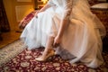 Wedding, the bride in a white dress puts on her beautiful shoes Royalty Free Stock Photo