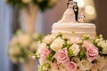 A wedding cake adorned with beautiful pink and white flowers, ready to be enjoyed by the guests, A wedding cake adorned with fresh Royalty Free Stock Photo