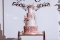 Wedding cake. Close-up photo of a beautiful white three-tiered wedding cake decorated by flowers and greenery Royalty Free Stock Photo