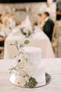 Wedding cake decorated with flowers stands on a dish on the table Royalty Free Stock Photo