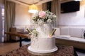 Wedding cake decorated with flowers on the table Royalty Free Stock Photo