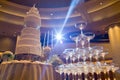 wedding cake on flower near Champagne glass pyramid.