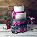 Wedding cake ornamented in rustic style blue and purple roses