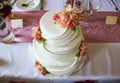 A wedding cake with pink marzipan roses on a table Royalty Free Stock Photo