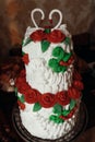 wedding cake with swans on top, decorated with red roses in ukrainian style Royalty Free Stock Photo