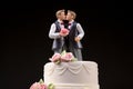 Wedding cake topper with two grooms, figurines of a gay couple. Gay marriage concept. Same-sex gay marriage, wedding sweets and