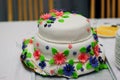 Wedding cake in white glaze decorated with colorful flowers Royalty Free Stock Photo