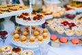 Wedding candy bar with different colored bright cupcakes, macaroons, cakes, jelly and fruits Royalty Free Stock Photo