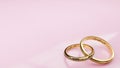 Wedding card Perfect fit - pink background and two golden rings joined together forever with engraved words Royalty Free Stock Photo