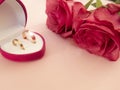 Wedding celebration with pink rose bouquet, gold wedding rings in the pink boxe, isolated on pink background. Concept of love and