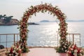 Wedding ceremony arch setup on the beach at the sea decorated with flowers and green leaves. Beautiful wedding decor Royalty Free Stock Photo